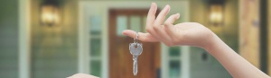 Mani con chiavi sfondo porta di casa
